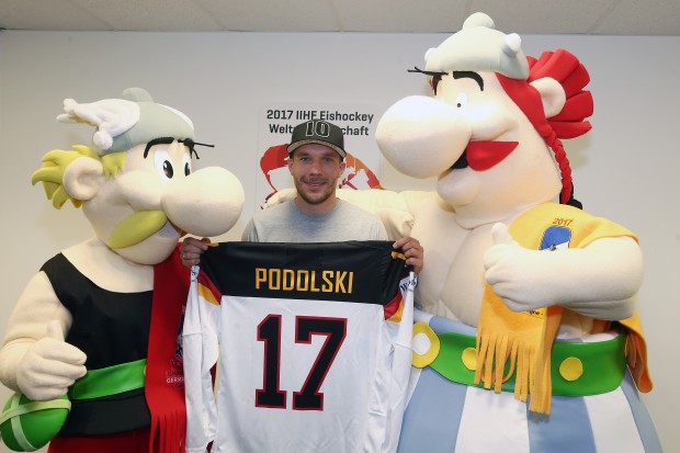 Die WM-Maskottchen Asterix und Obelix überreichten Lukas Podolski ein DEB-Trikot. Foto: Herbert Bucco